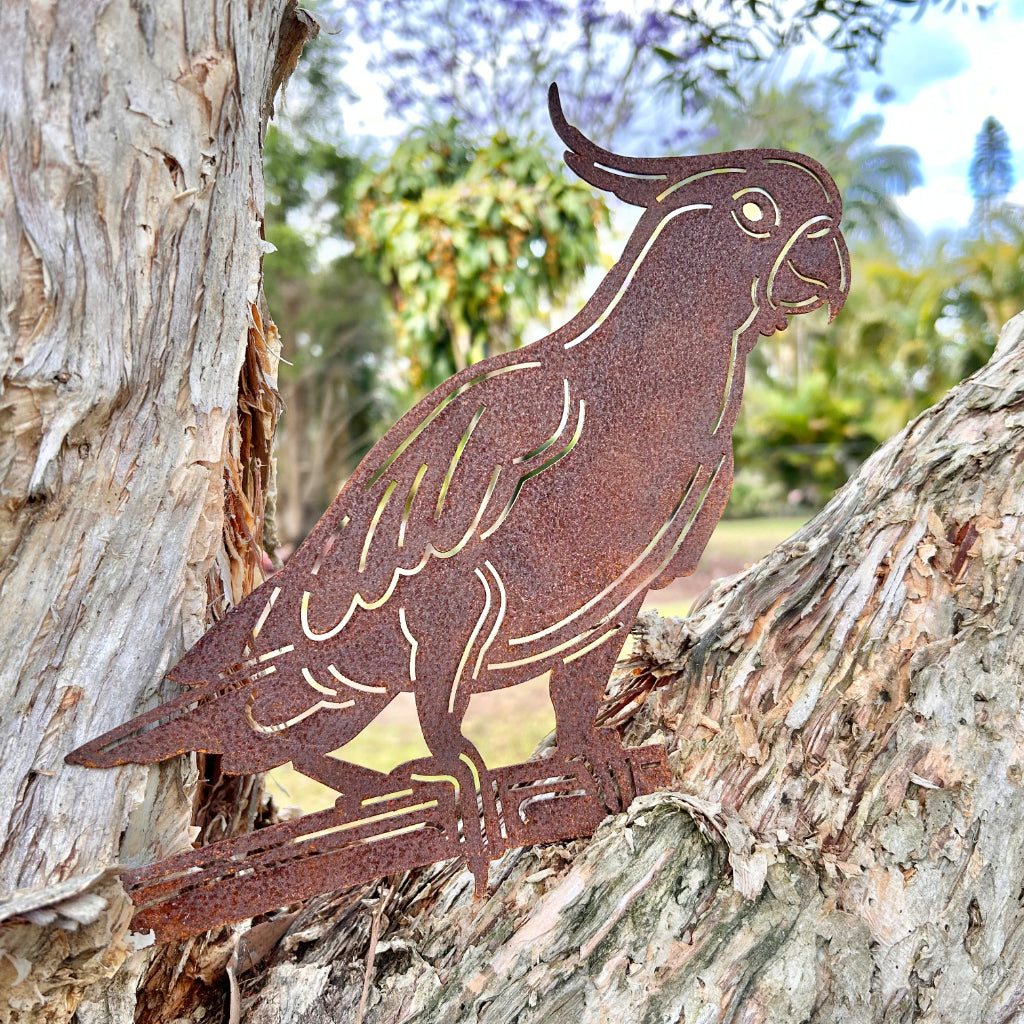 Metallic cockatoo bird sculpture in a paper bark tree