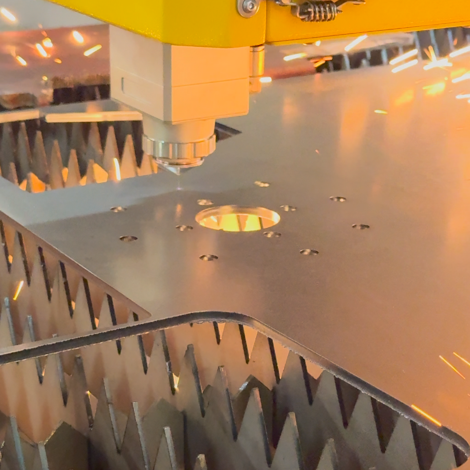 Metalworking process with a machine cutting metal, creating sparks.